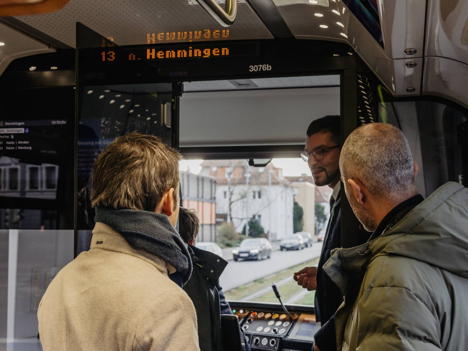 2 Personen, denen etwas mit Blick aus der Fahrerkabine einer Stadtbahn erklärt wird.