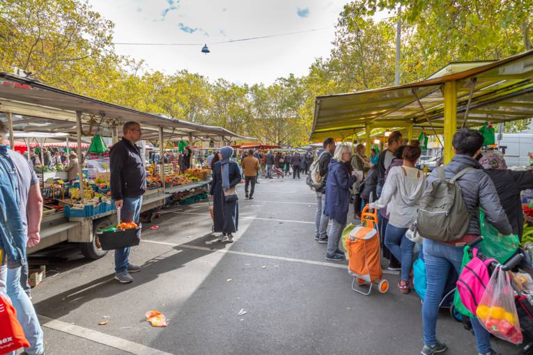 Kundschaft läuft zwischen Marktständen umher - Szenen vom Wochenmarkt Mitte an einem Samstag.