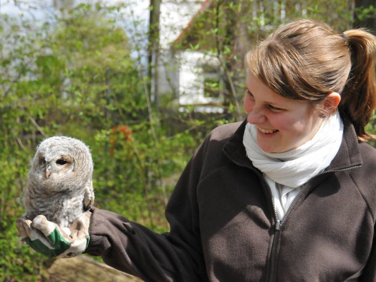 Junge Frau mit Eule in der rechten Hand