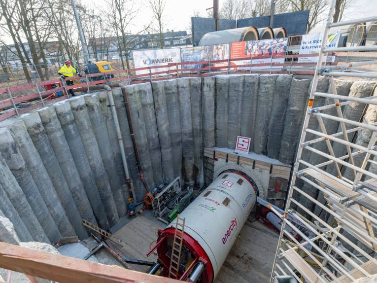 Blick in eine große runde Baugrube mit einer Tunnelbohrmaschine darin.