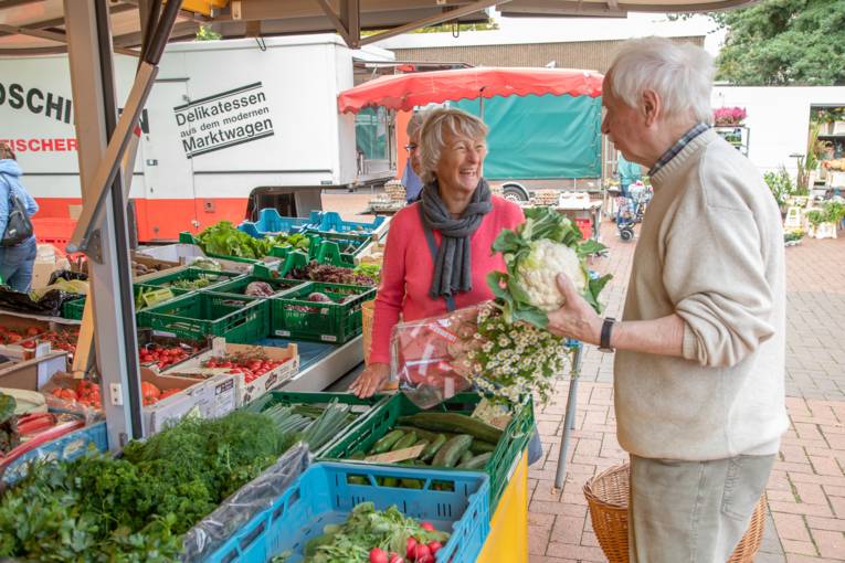 Menschen an einem Stand auf dem Wochenmarkt Davenstedt.