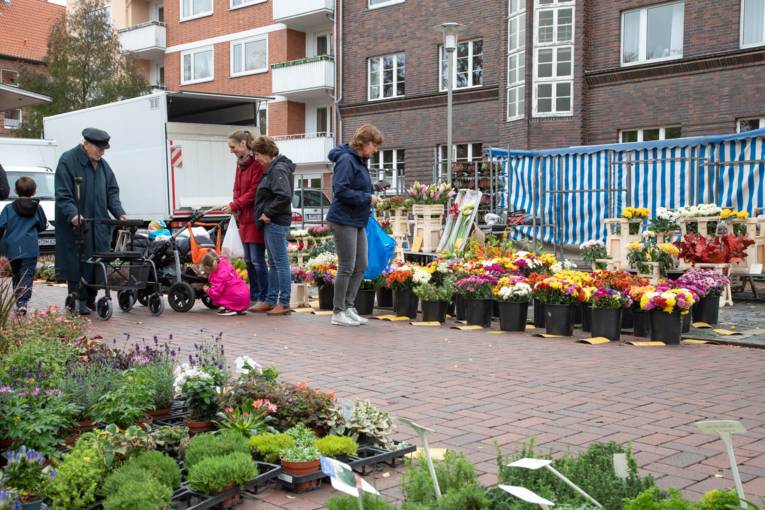 Menschen unterschiedlichen Alters auf dem Wochenmarkt.