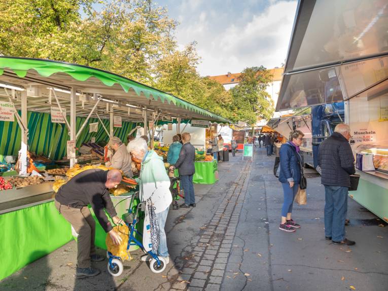 Menschen unterschiedlichen Alters erledigen ihre Einkäufe auf dem Wochenmarkt Schaperplatz.